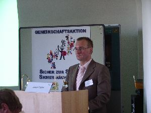 Der Referent schaut – wie wenn er noch bei der richtigen Polizei wäre – aber unser Plakat kommt gut auf das Bild (Zur Erläuterung: Herr Polster wurde erst kürzlich vom PP München an das Ministerium abgeordnet. Beim PP in München, sagt er gerne, war er noch ein echter Polizist, jetzt ist er mehr ein „Schreibtischler“)