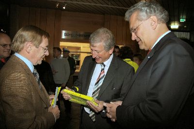 Der Gesch�ftsf�hrer der Gemeinschaftsaktion �bergibt dem B�rgermeister gelbe Klackb�nder f�r die ABC-Sch�tzen in Unterf�hring, die er anschlie�end in der Aula bei seiner Begr��ungsrede austeilen l�sst � hoffentlich nach der Rede, weil sonst alle Kinder schon w�hrend der Rede �klackern�