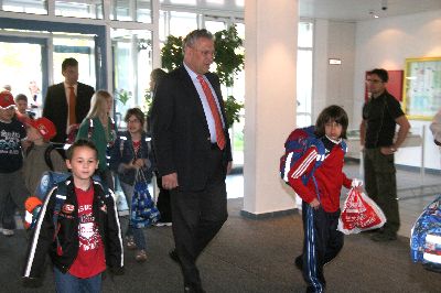 In der Aula der Schule gehen die Kinder in ihre Klassenzimmer und der Minister zum Schulleiter