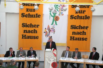 GA-Fahnen und Verkehrsexperten an den Tischen umrahmen den Minister